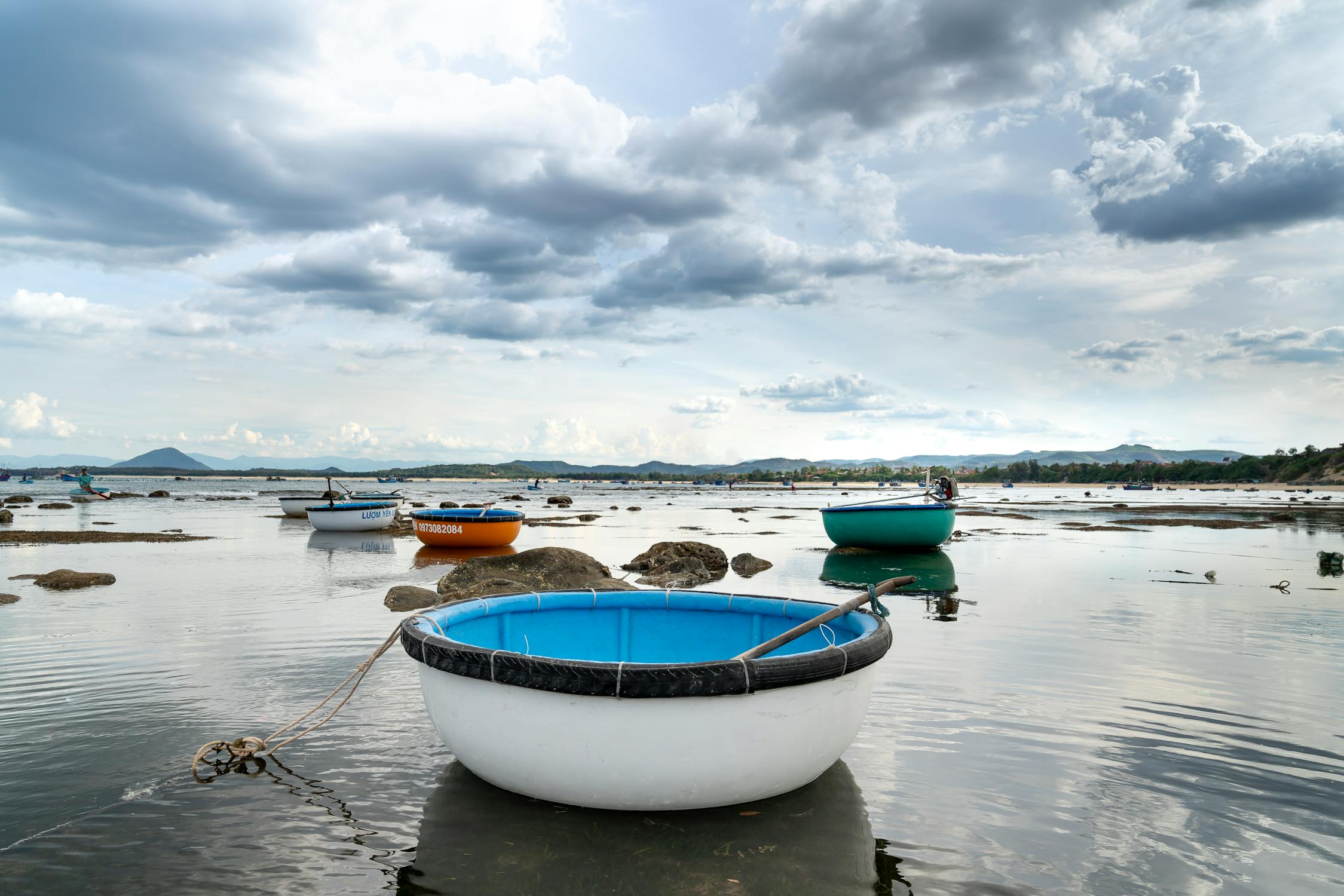 Round boats moored on sea water under cloudy sky ©Quang Nguyen Vinh